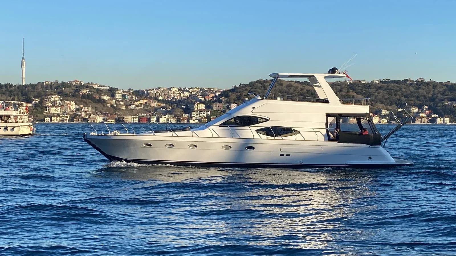 Side-by-side view of an Istanbul Bosphorus cruise yacht and a Princes Islands ferry with Buyukada in the distance