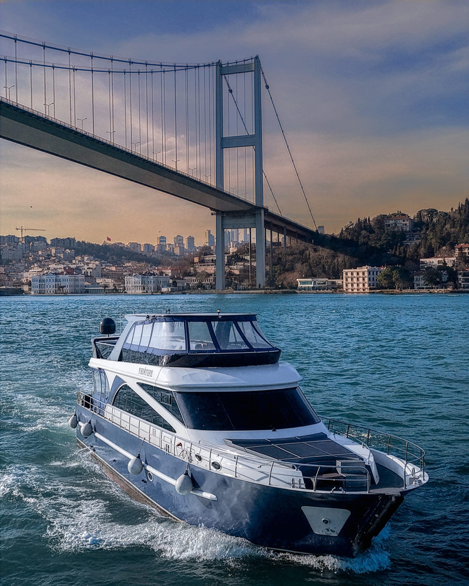 Bosphorus strait with both passenger yachts and city ferries crossing under the Bosphorus Bridge